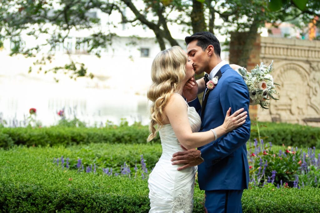Bride and groom sharing a kiss with his hand on her chin at Hotel Baker.