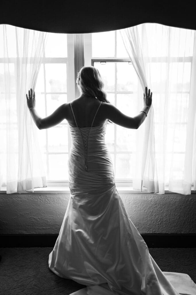 Pride holding open curtains in the bridal suite at Hotel Baker Saint Charles IL.