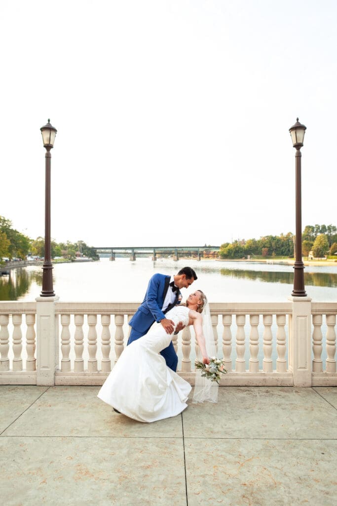 Groom dipping bride by the Fox River at Hotel Baker.
