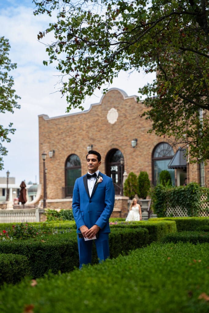 Groom waiting his bride in the ENglish-style garden at Hotel Baker.