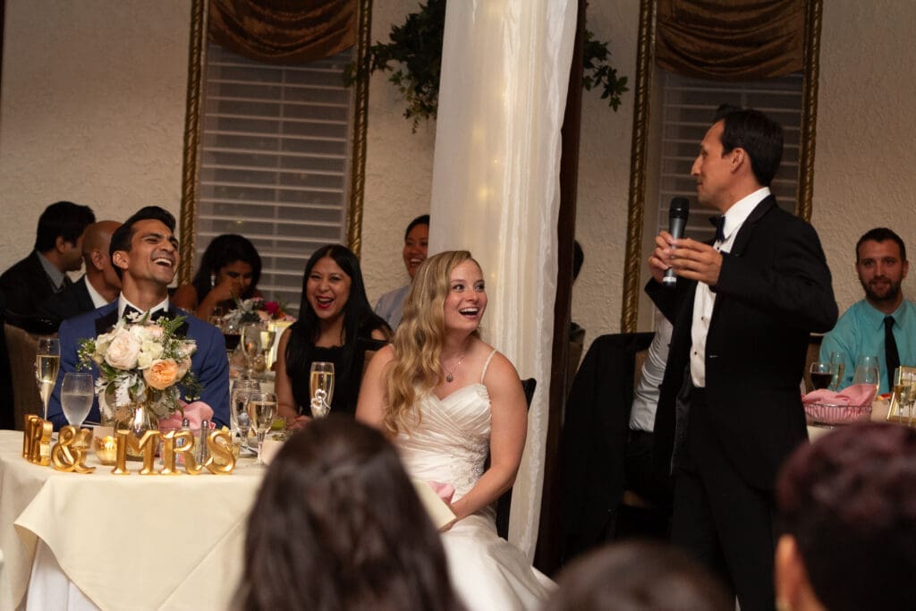 Smiling bride during speeches in the Rainbow Room at Hotel Baker.