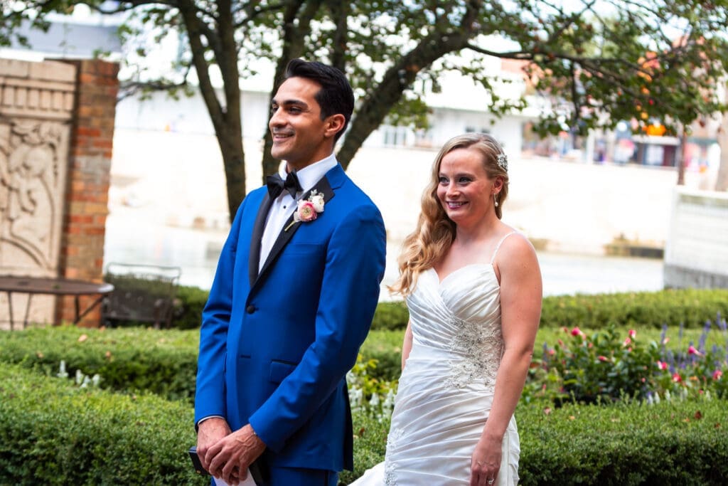 Bride and groom about to see each other for their first look at Hotel Baker's garden.
