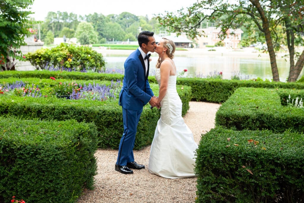 Bride and groom see each other for the first time and kiss in the private English style garden at Hotel Baker Saint Charles IL.