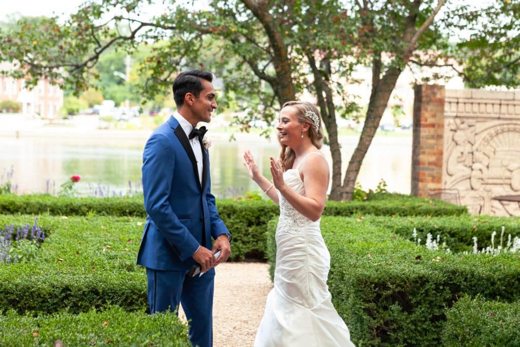 Bride and groom see each other for the first time on their wedding day at Hotel Baker and smiling shocked at each other in joy.
