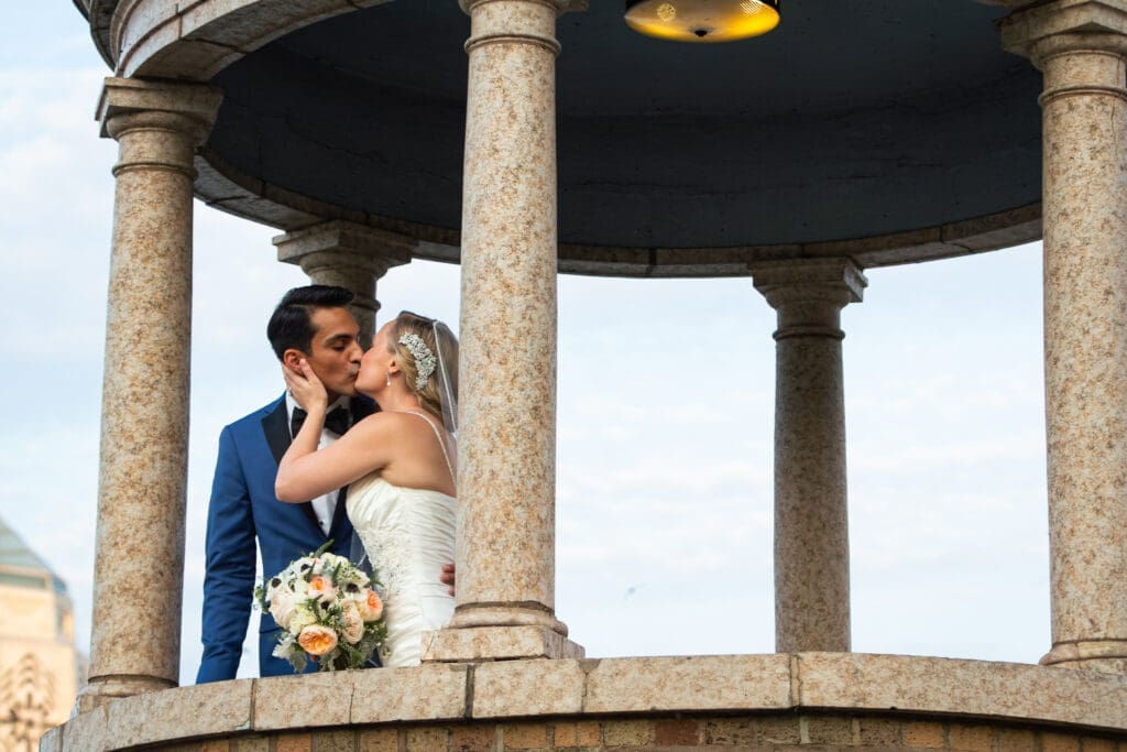 Bride and groom kissing in the gazebo by the Fox River at Hotel Baker.