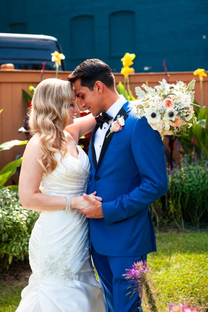 Bride and groom looking at each other with their foreheads together and hands held at Hotel Baker.