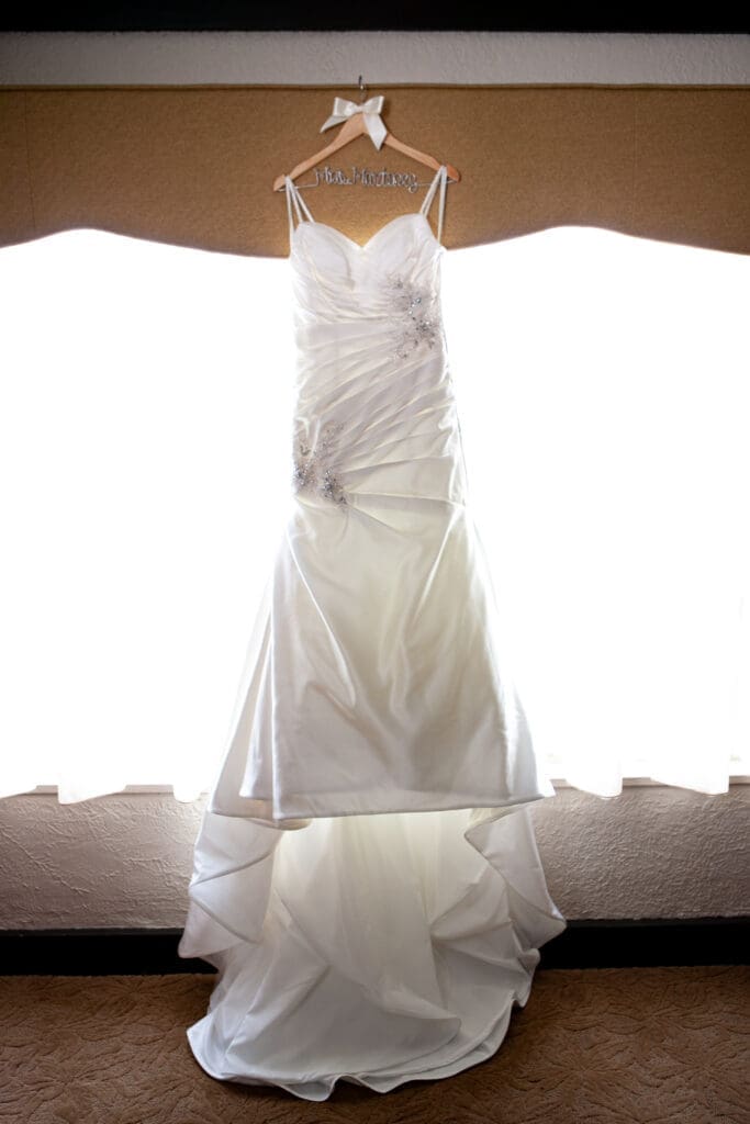Beautiful vintage luxury wedding dress hanging in the bridal suite room at Hotel Baker St. Charles IL.