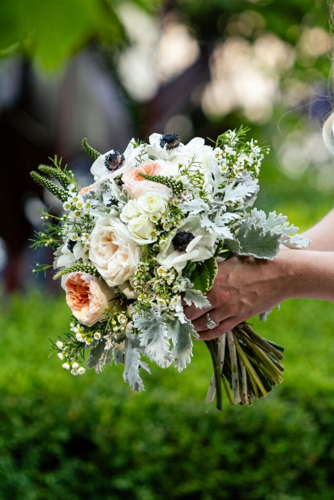 Bride holding a beautiful luxury bouquet of flowers the garden of Hotel Baker Saint Charles Illinois.
