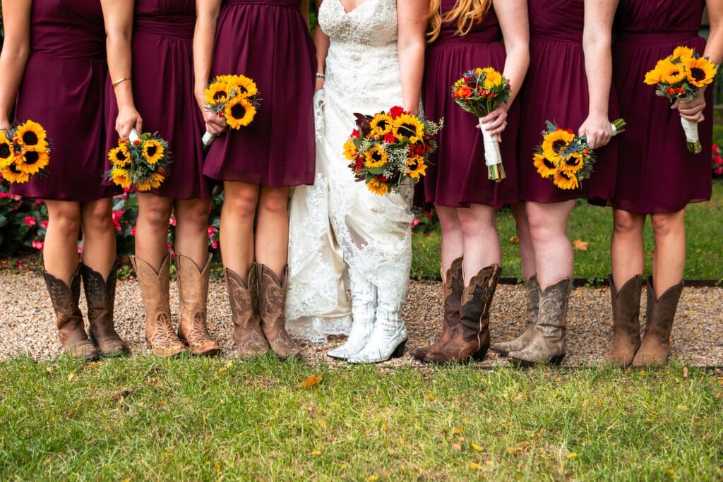 Bride and bridesmaids with flowers and boots.