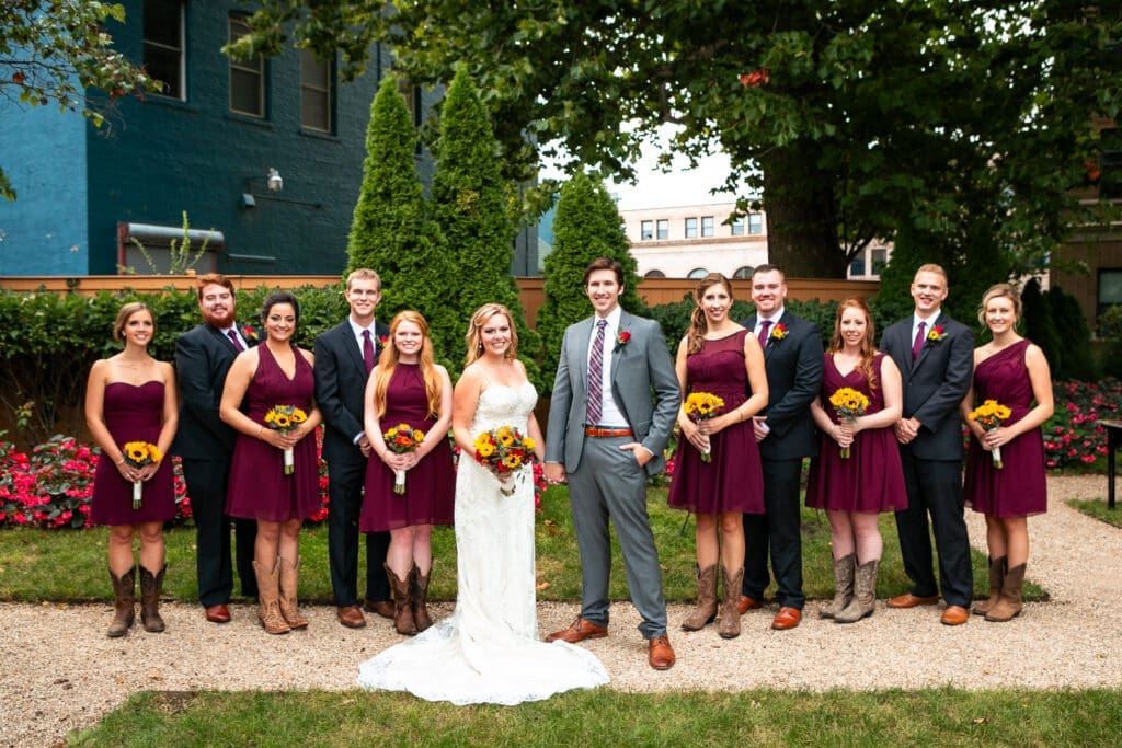 Modern bridal party with bride and groom at Hotel Baker garden.