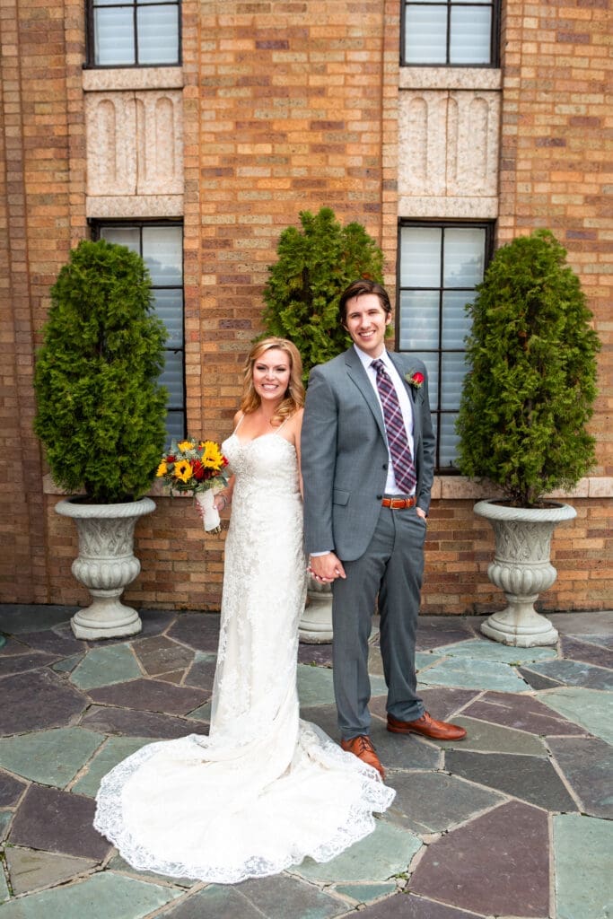Bride and groom smiling and posing outside the Rainbow Room at Hotel Baker.