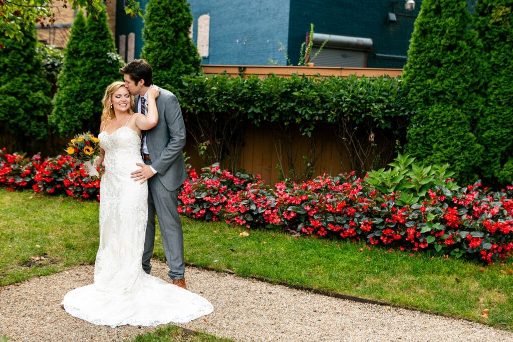 Groom kisses brides head as she holds him at Hotel Baker Saint Charles.