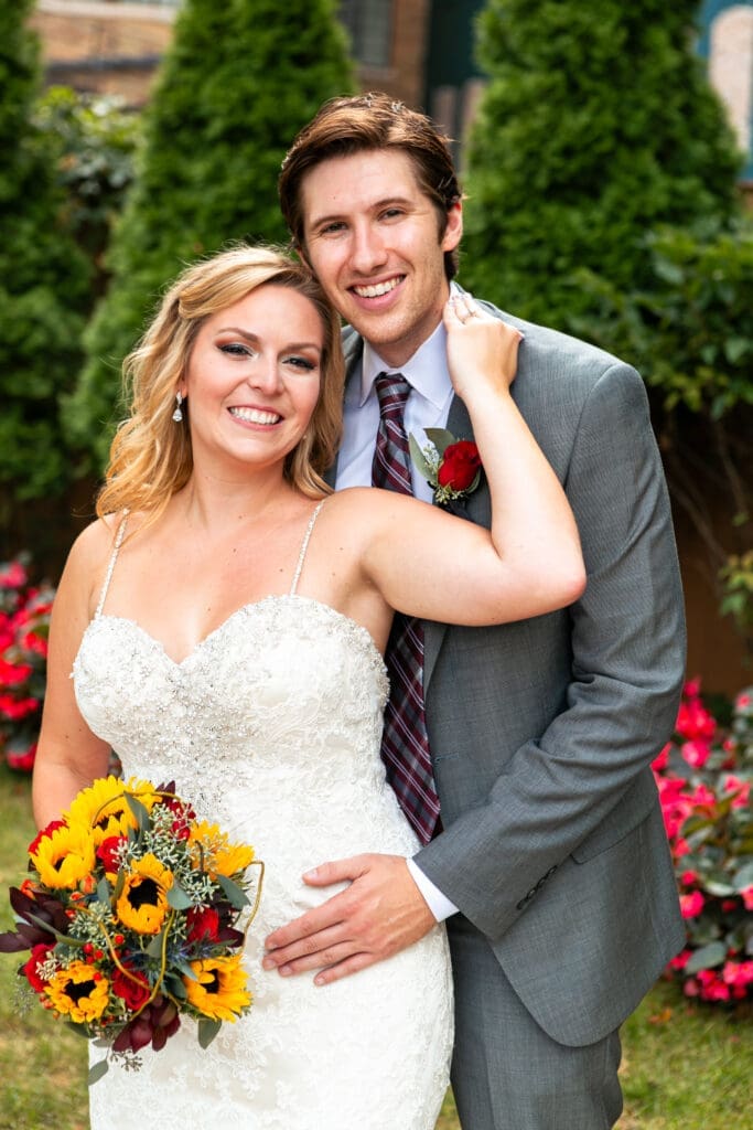 Smiling bride and groom at Hotel Baker ivy garden.