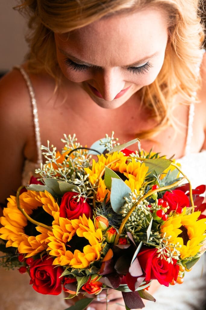 Beautiful bride looking down into her gorgeous bouquet on wedding morning.