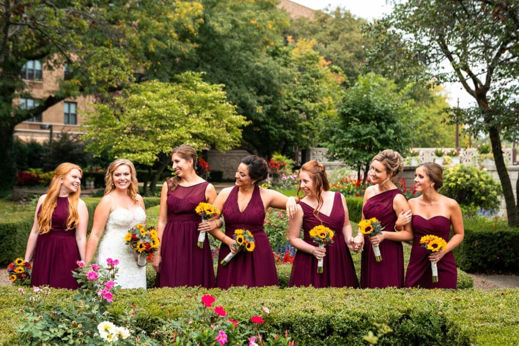 Bridesmaids adoring bride looking at her in the garden at Hotel Baker Saint Charles IL