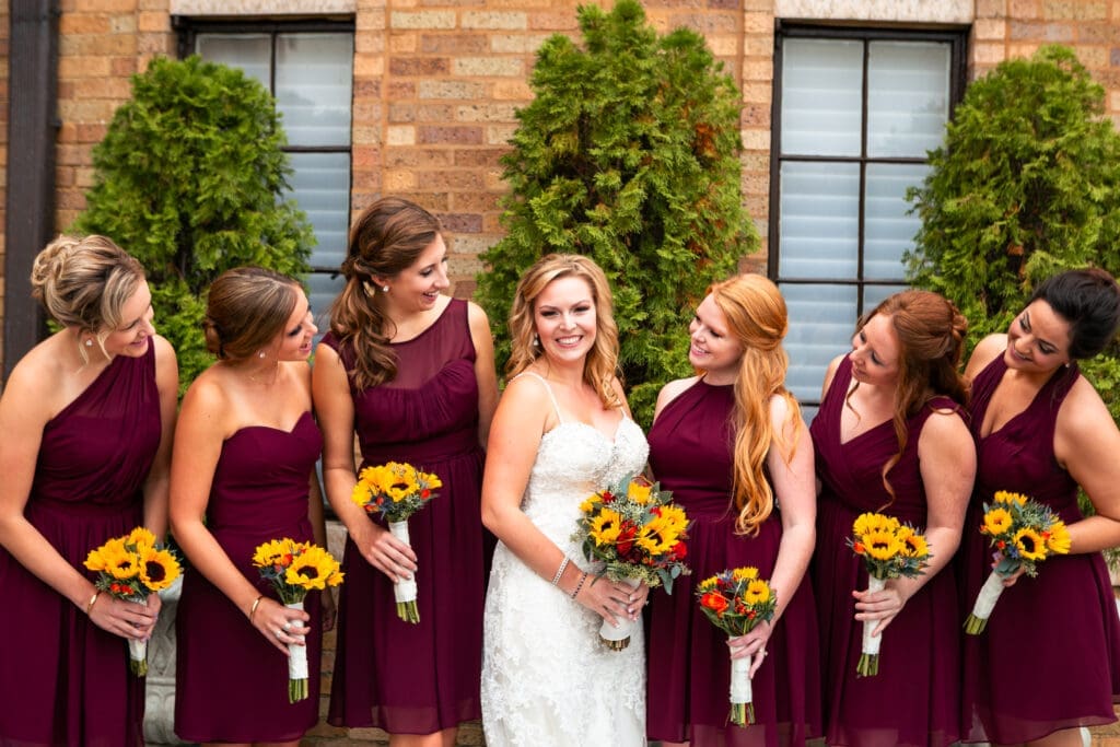 Bridesmaids looking at bride in the garden at Hotel Baker.