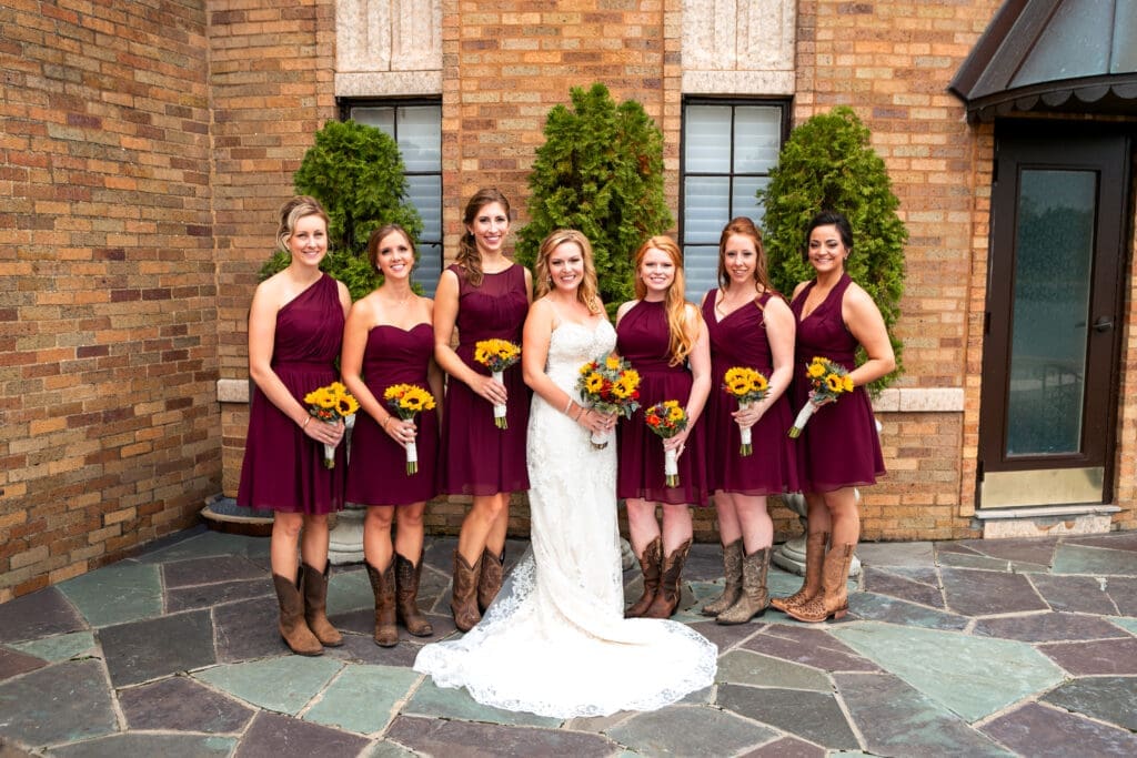 Bride and bridesmaids together in front of the Rainbow room at Hotel Baker.
