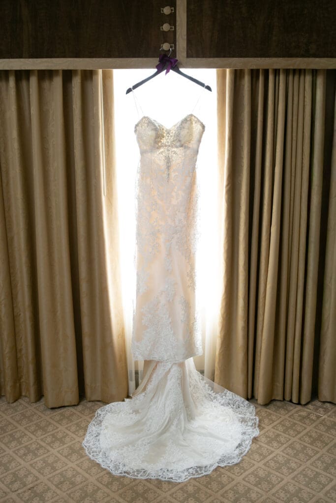 Wedding gown hanging in the window at Hotel Baker St. Charles.
