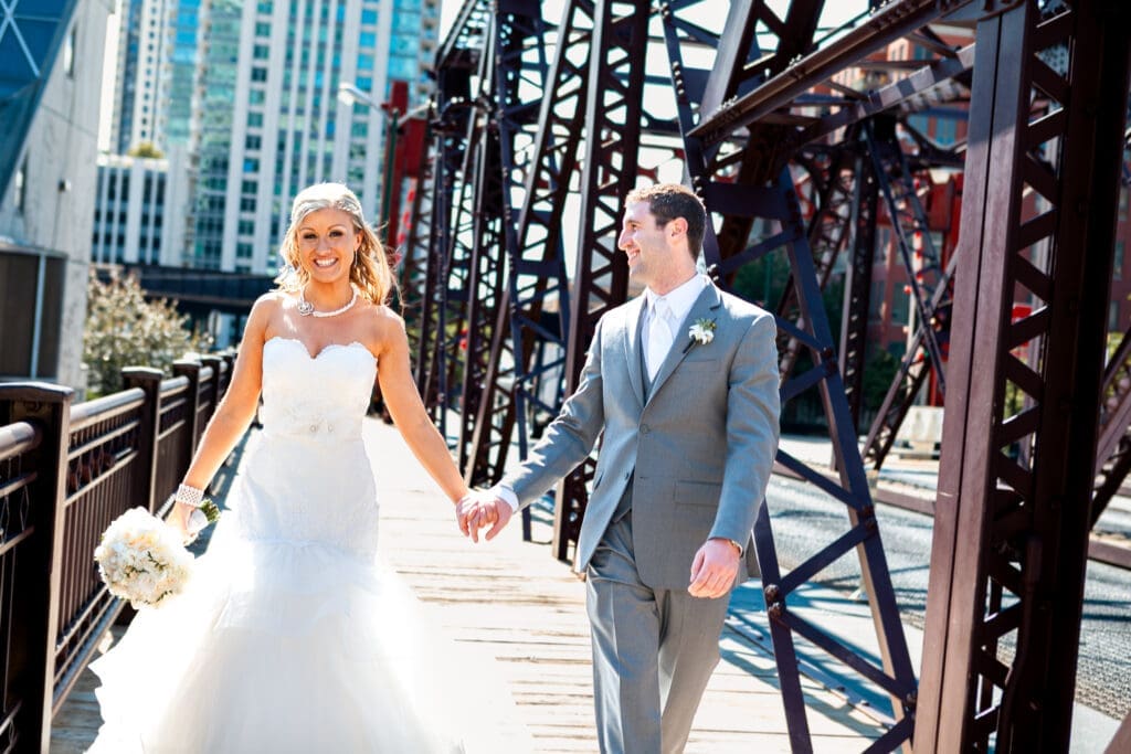 Groom admiring his beautiful bride as they walk on a bridge overlooking the Chicago River.