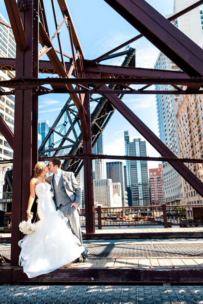 Bride and groom kissing on Kinzie and Canal railroad bridge over the Chicago River.