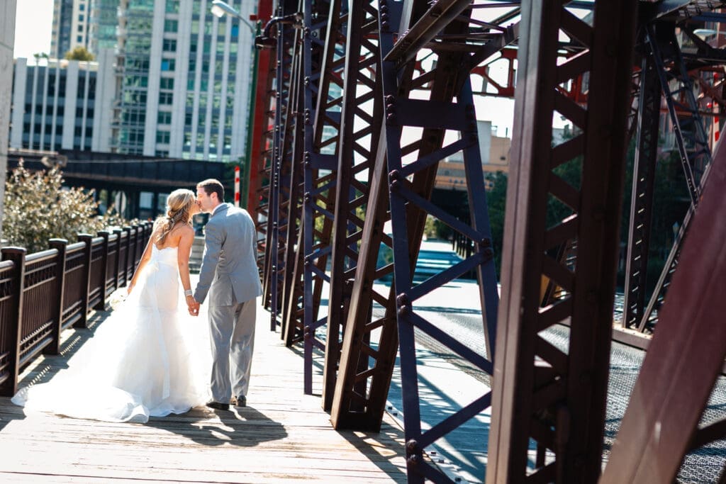 Bride and groom sharing a kissing together on a bridge in Chicago over the Chicago River.