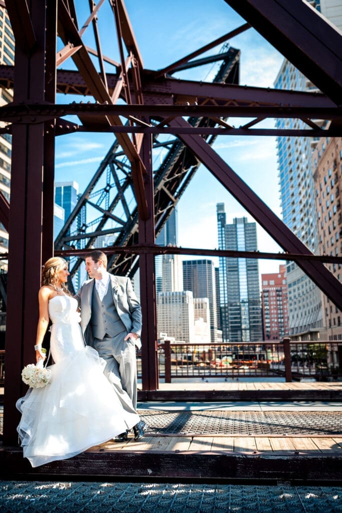 Bride and groom looking at each other on the Kinzie Canal railroad bridge overlooking the Chicago River.