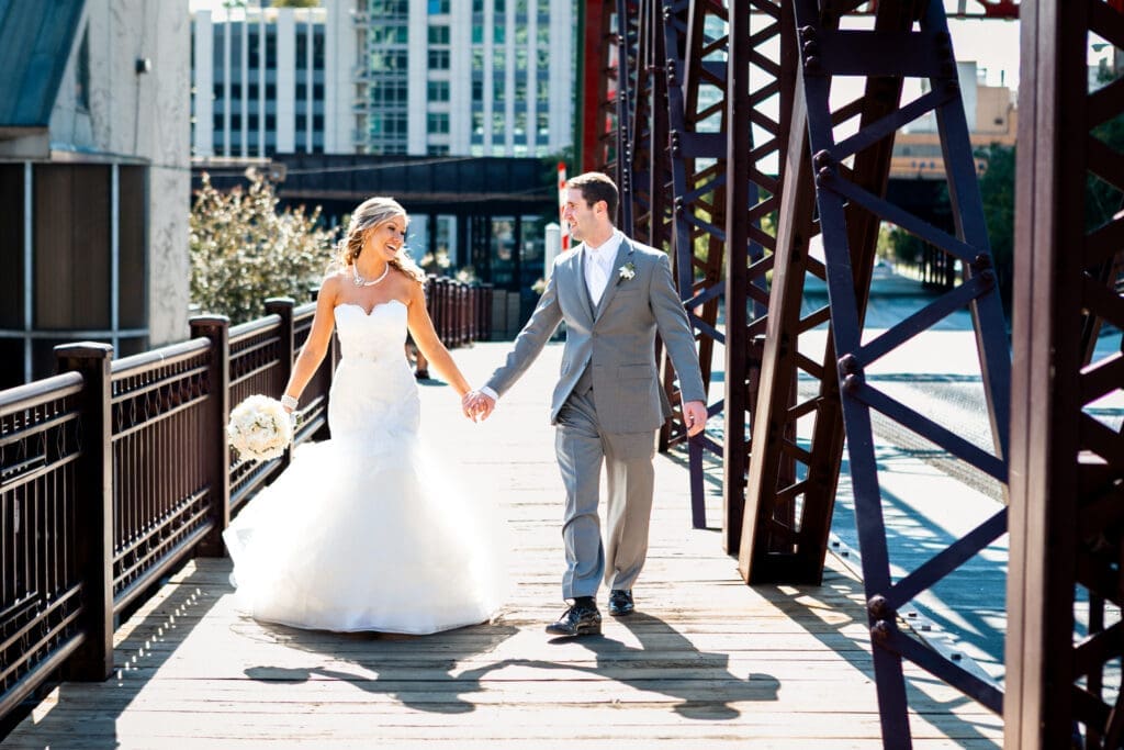 Bride and groom strolling on a bridge together in Chicago on their wedding day.