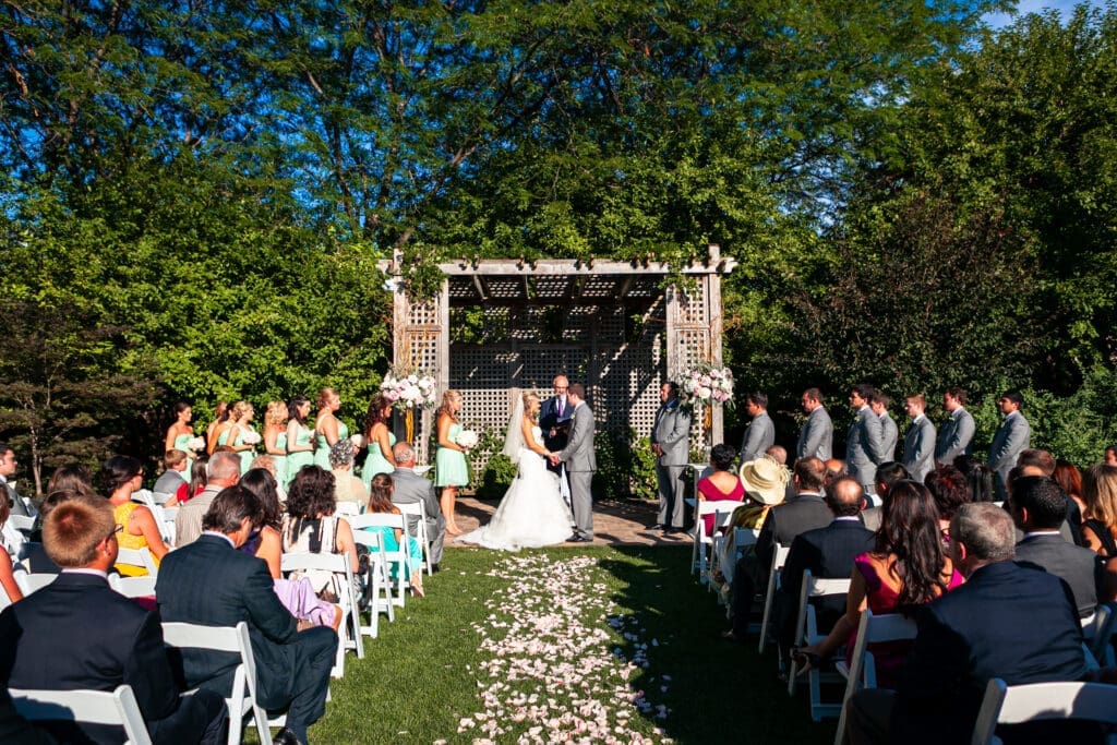 Bride and groom saying their vows while holding hands in front of their friends and family at a private estate wedding ceremony in Chicago.