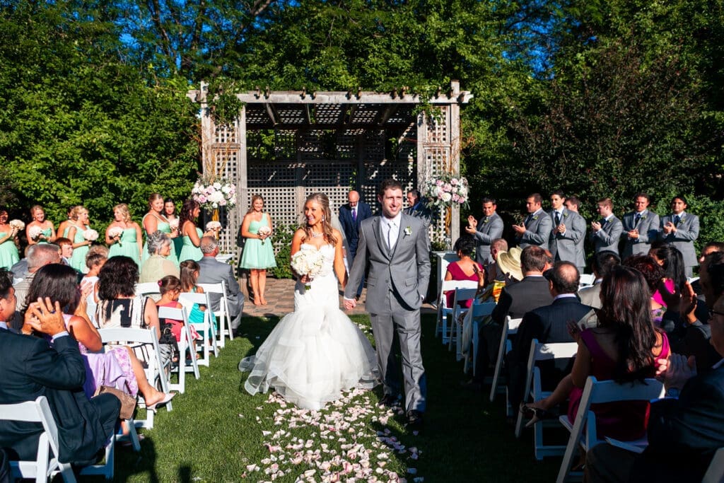 Bride and groom after just being married walking down the aisle at a private estate wedding ceremony.