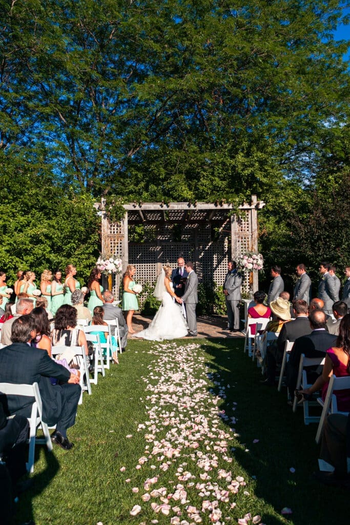 Bride and groom saying their vows while holding hands in front of their friends and family at a private estate wedding ceremony in Chicago.