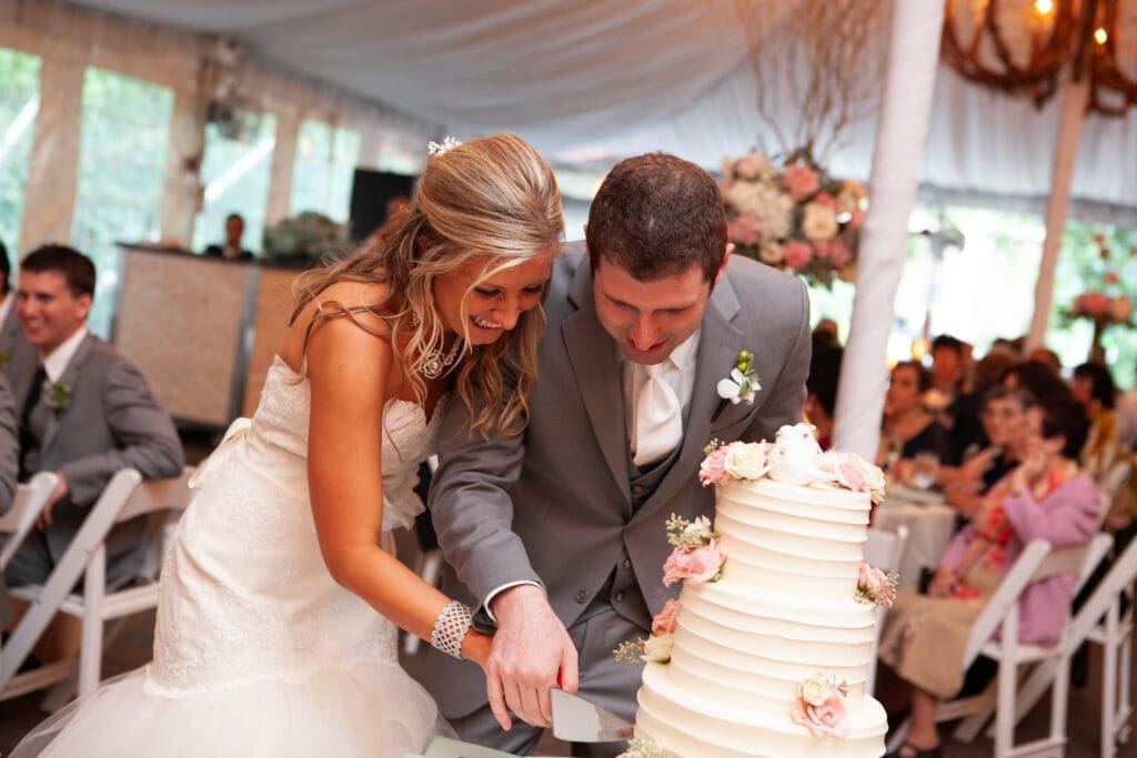 Bride and groom cut into their wedding cake together atr a private estate wedding reception in Chicago.