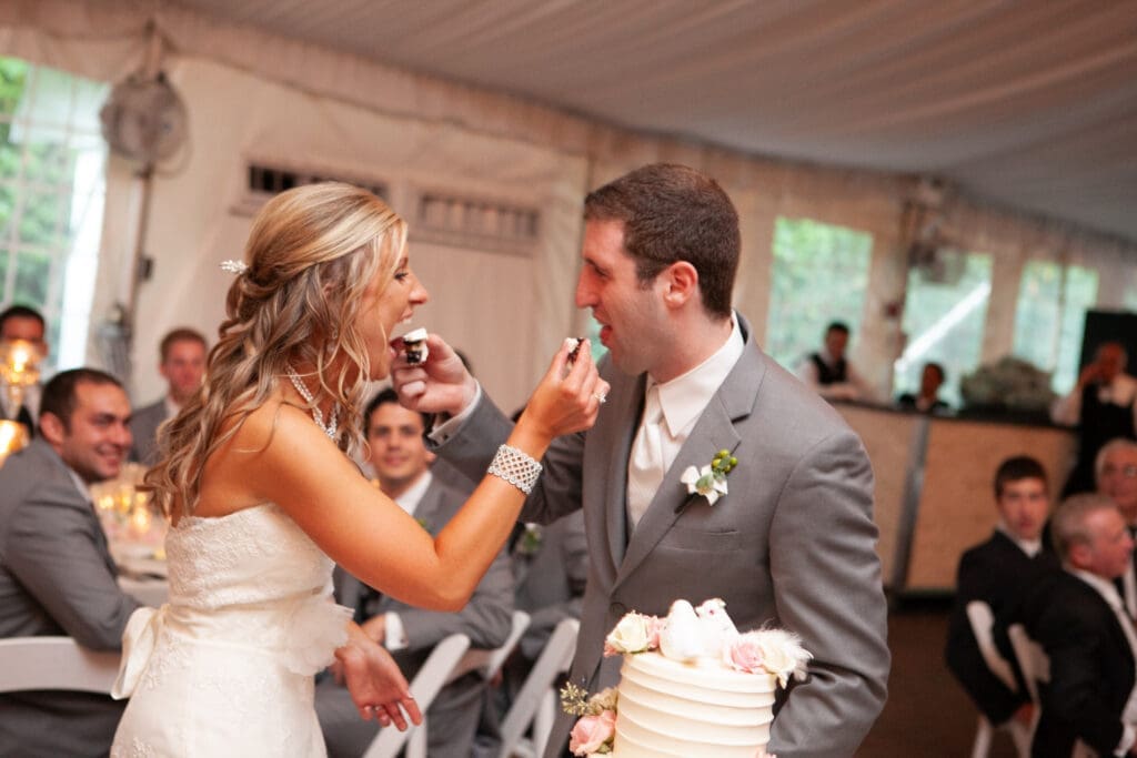 Bride and groom feeding each other cake at their private estate wedding reception in Chicago.