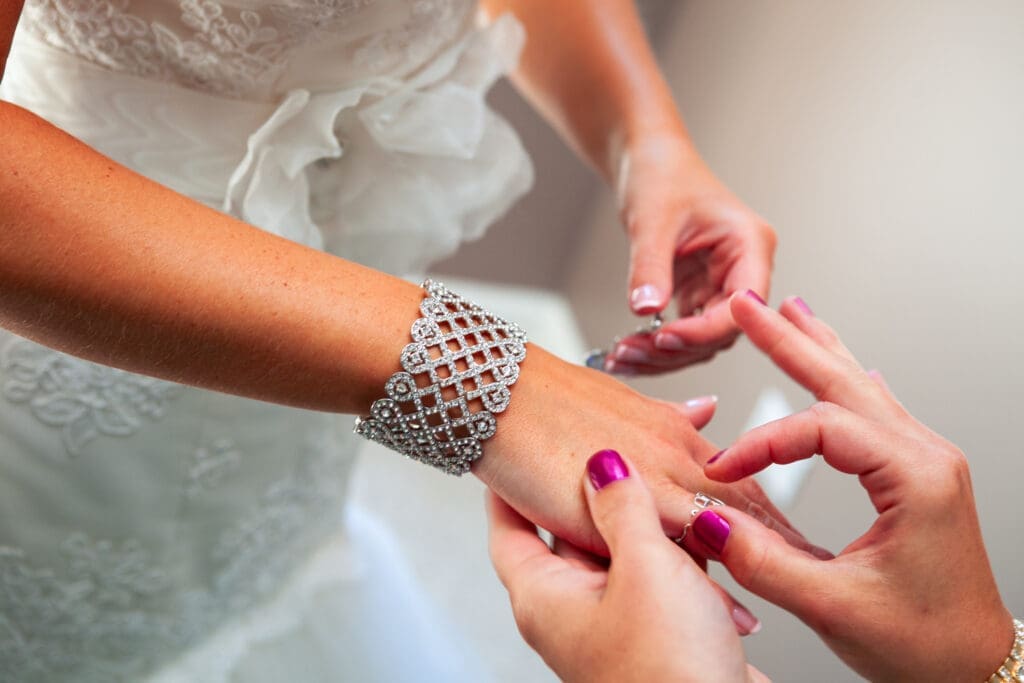 Bridesmaid helping bride put on her jewelry in Chicago at the Langham.