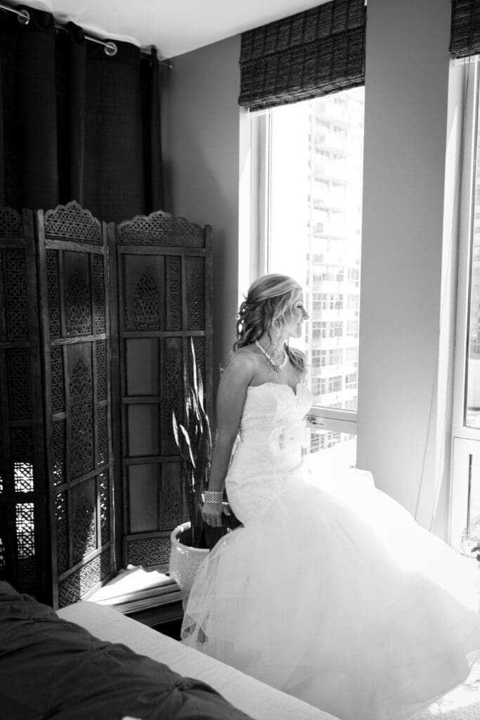 Bride sitting looking out the window on a sunny day at the Langham Hotel Chicago.