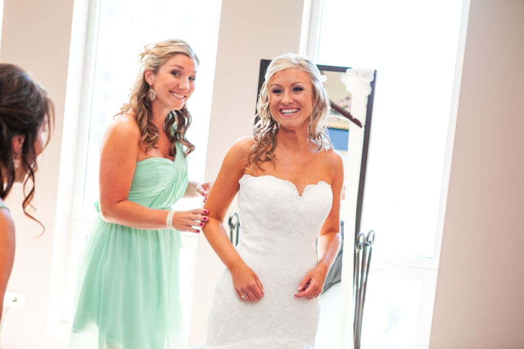 Bride beaming a smile at her bridesmaids while getting ready at the Langham.,