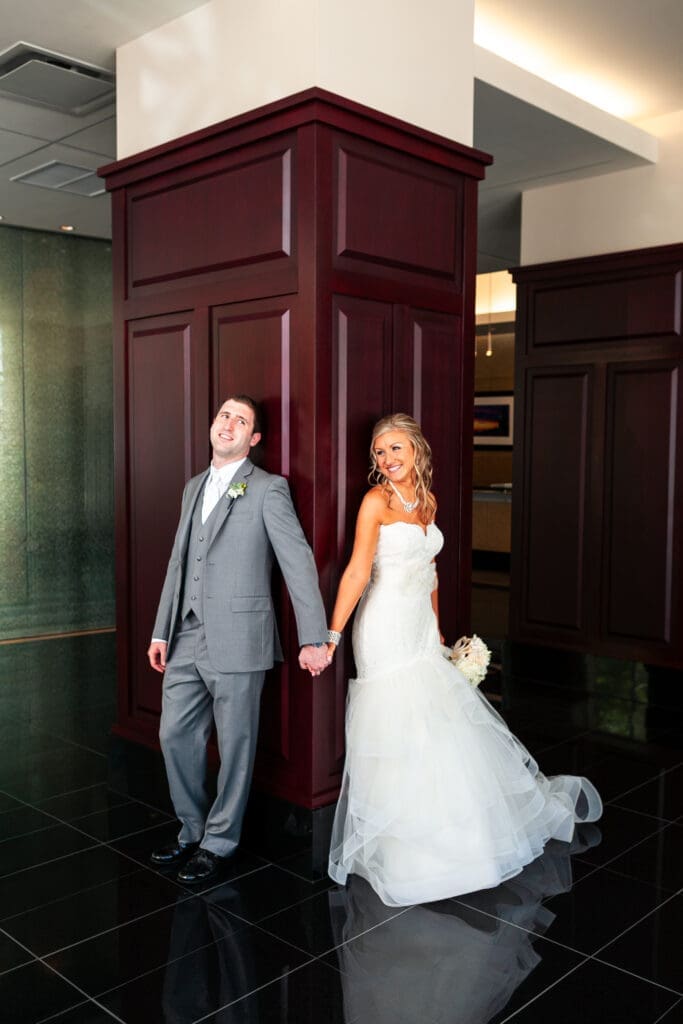 Bride and groom holding hands and smiling at the Langham Chicago before their first look.