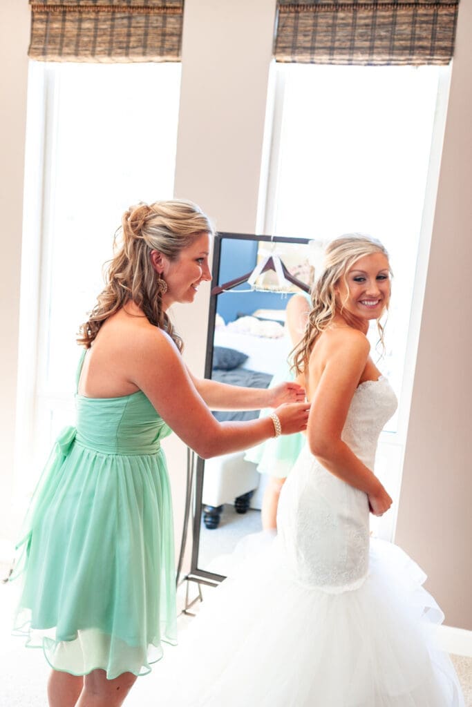 Maid fo honor fixing bride's dress at the Langham Chicago.