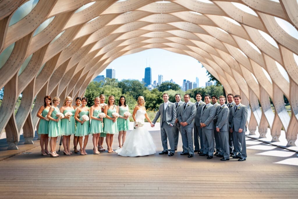 Bride and groom with their bridal party at Lincoln Park Zoo with the Chicago skyline behind them.