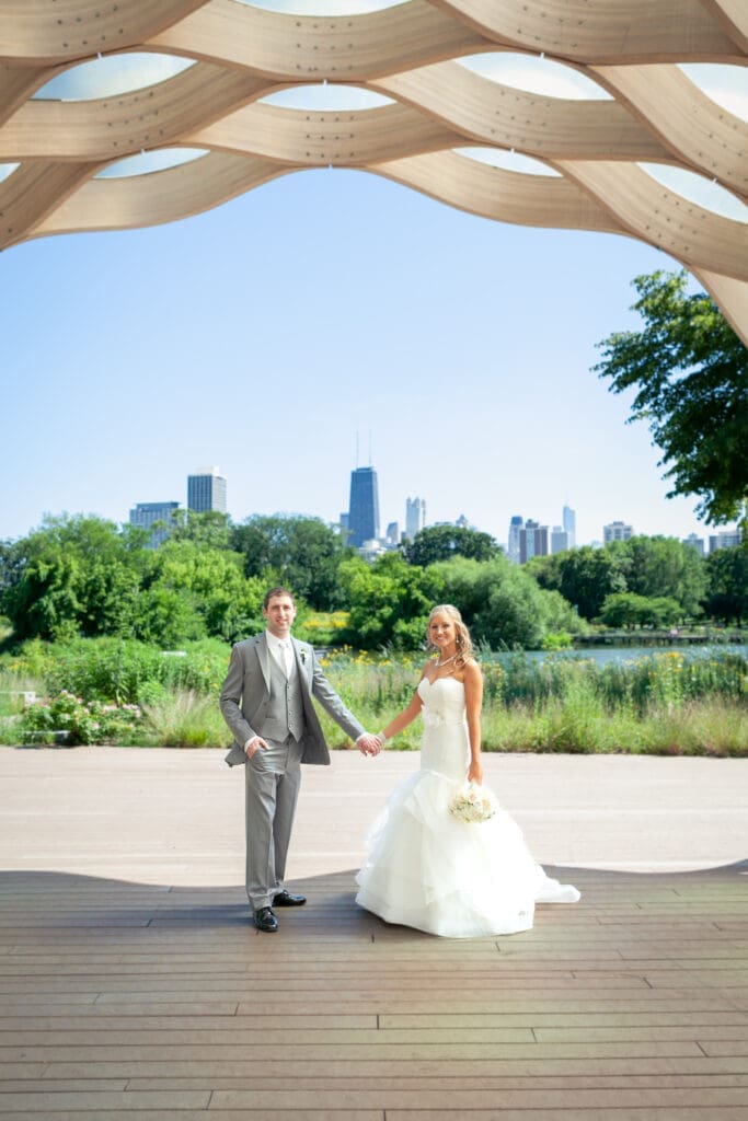 Bride and groom at Lincoln Park Zoo with the Chicago skyline behind them.