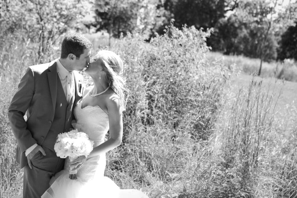 Bride and groom kissing in prairie grasses at Lincoln Park Zoo Chicago black and white.