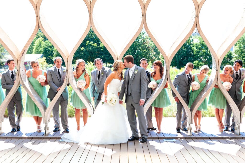 Bride and groom kissing with bridal party around them at the North pond Lincoln Park Zoo Chicago.