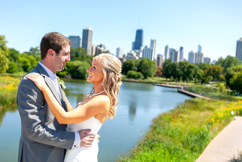 Bride and groom looking at each other in front of the Chicago city skyline at Lincoln Park Zoo..