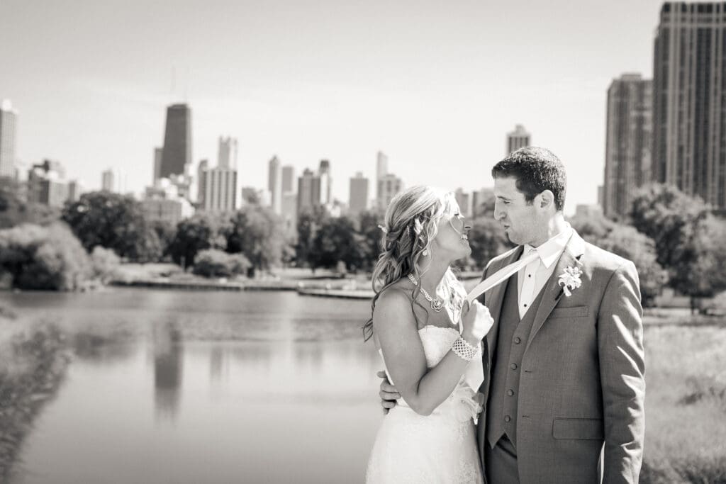 Bride grabbing the groom's tie to pull him in closer in front of the4 Chicago city skyline.