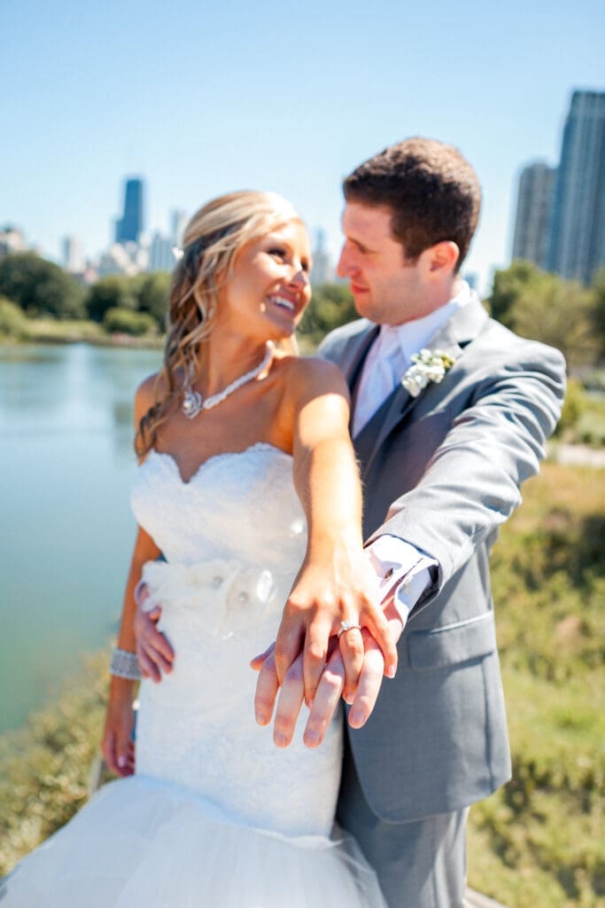 Bride and groom holding hands showing off their wedding rings at Lincoln Park Zoo Chicago.